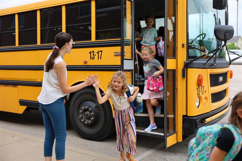 Students walk off a school bus